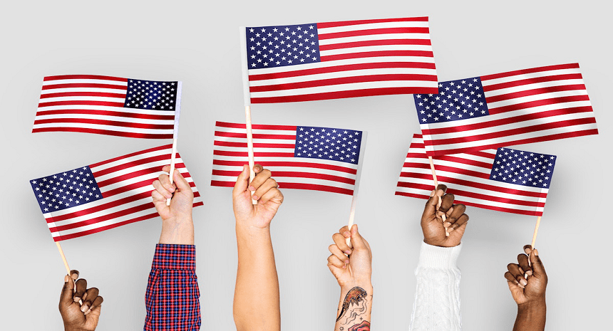 A group of people holding american flags in the air.