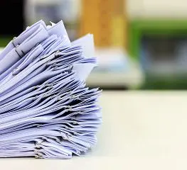 A stack of papers sitting on top of a table.