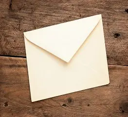 A white envelope sitting on top of a wooden table.