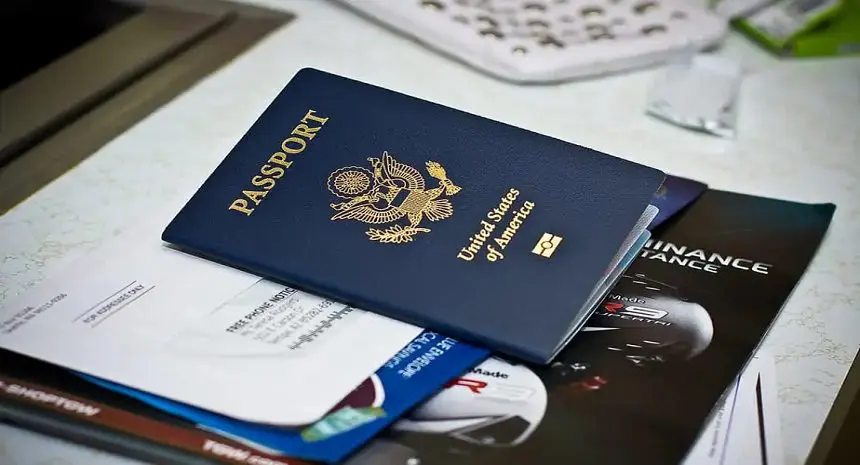 A passport sitting on top of some papers.