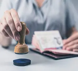 A person is sitting at a table with stamps