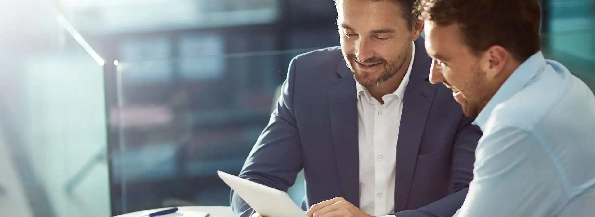 A man in a suit and tie holding an ipad.