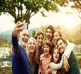 A group of people taking a selfie with a camera phone.