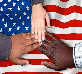 A group of people with their hands together in front of the american flag.