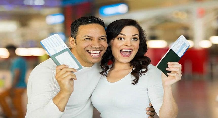 A man and woman holding up their passport.