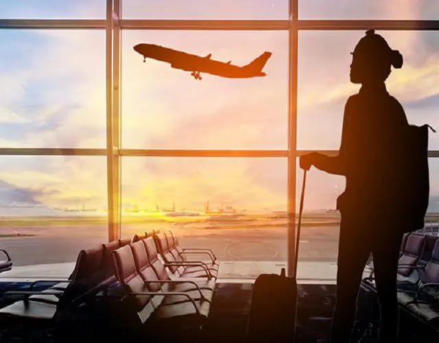 A person standing in front of an airport window.