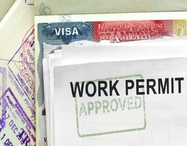 A work permit is shown on top of some papers.